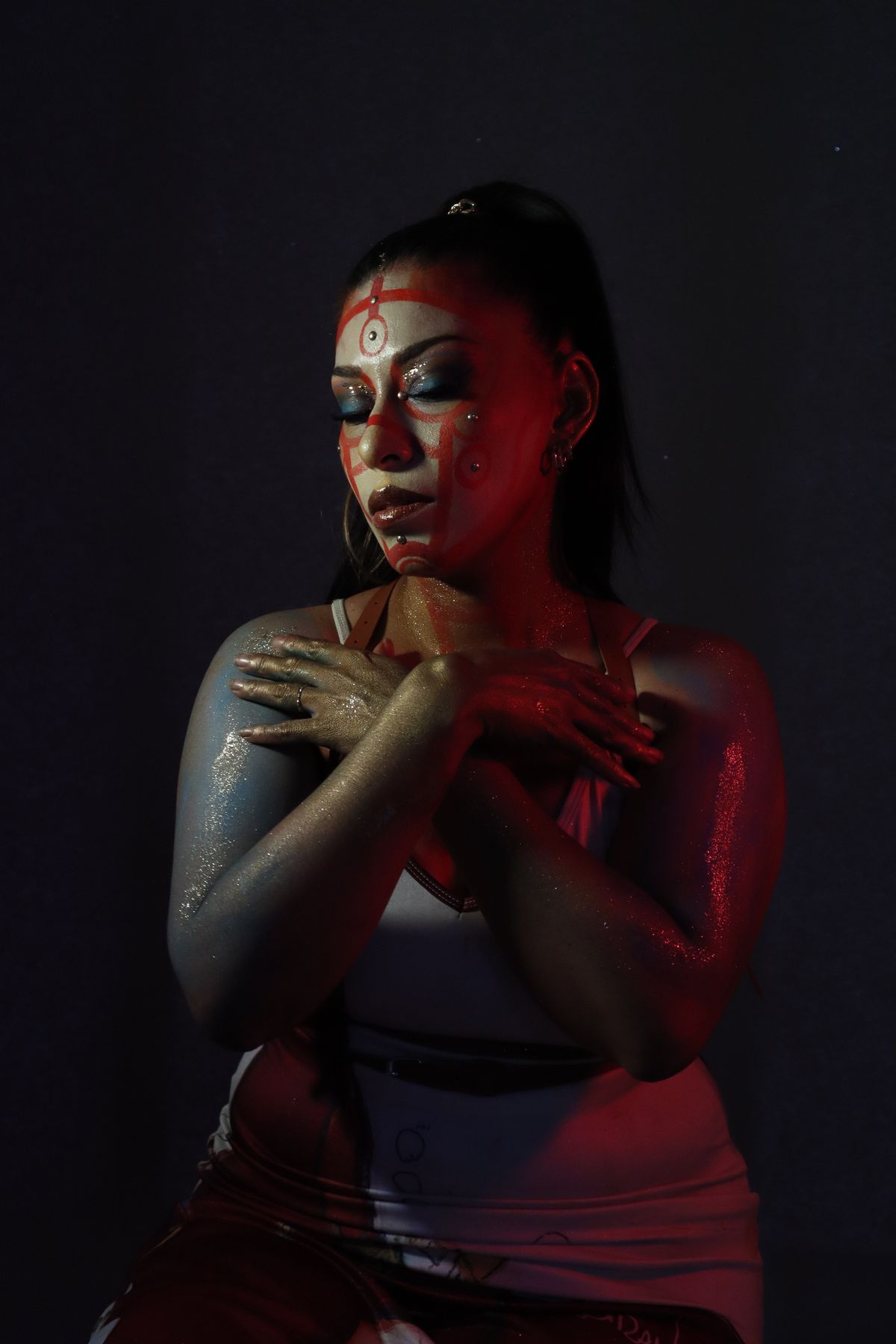 Model with bold dramatic makeup in red lighting, inspired by a luxury campaign.